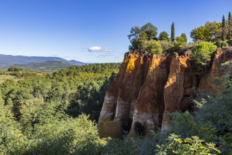 Ochre-colored cliffs on sunny day, Roussillon, Vaucluse, France.