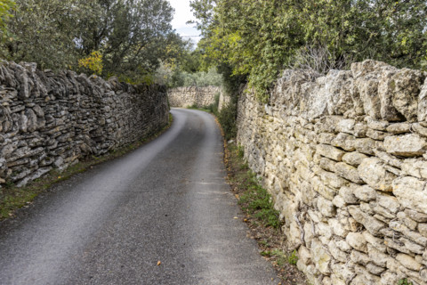 Empty path between old stone walls, Gordes, Vaucluse, France.