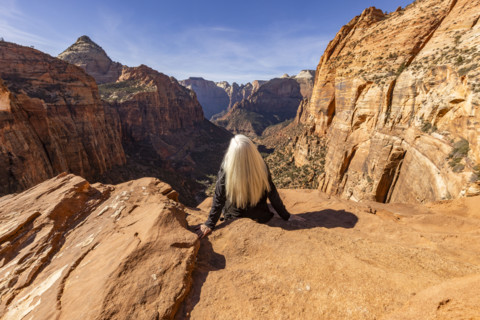Rear view of senior blonde woman at Zion Overlook, Zion National Park, Utah, USA.