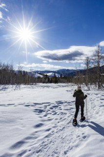 Rear view of senior woman snowshoeing in Sun Valley, Sun Valley, Idaho, USA.