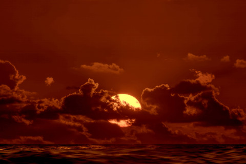 Sun rising through clouds over Atlantic Ocean, Boca Raton, Florida, USA.