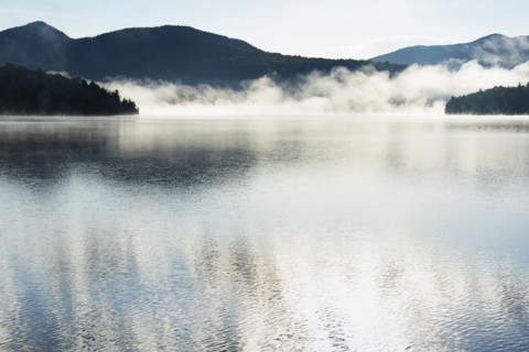 Autumn mist rising on Lake Placid, Lake Placid, New York, USA.