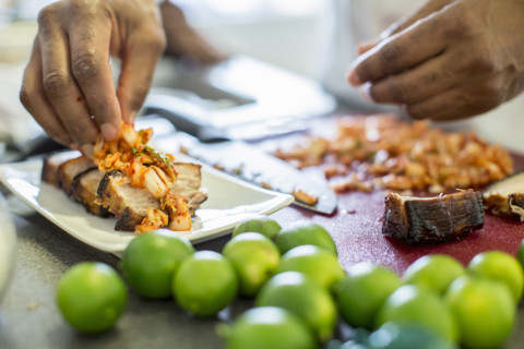Close-up of chef making pork belly and kimchee in restaurant, Los Angeles, California, USA.