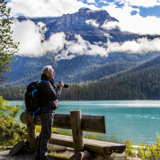 Man photographing mountain lake, Lake Louise, Alberta, Canada.
