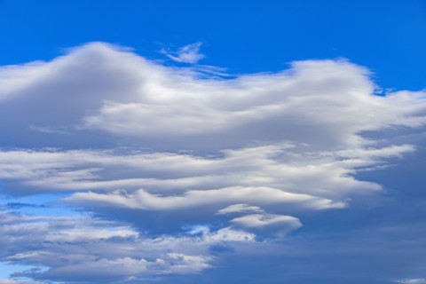 White lenticular clouds on blue sky