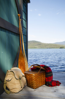 Backpack and picnic basket on pier on lake