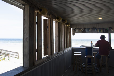 Rear view of man relaxing in seaside bar