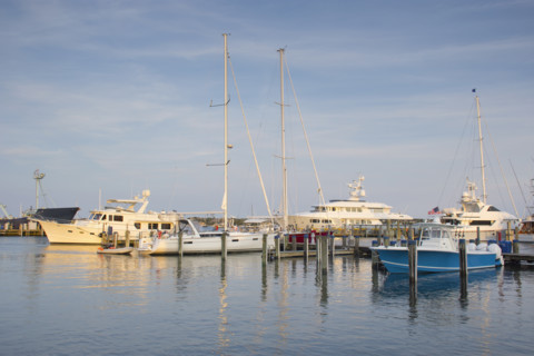 Boats moored at harbor at sunset