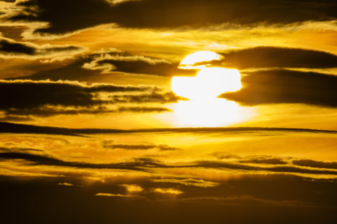 Golden sunset sky with dark clouds