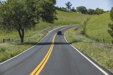 Empty road through green hills