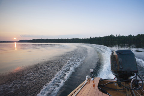 Motorboat wake on Saranac Lake at sunset