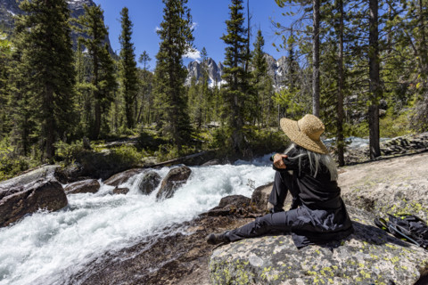 Senior woman resting on rock in Sawtooth Mountains