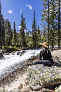 Senior woman resting on rock in Sawtooth Mountains