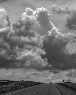 Dramatic sky above desert highway, black and white