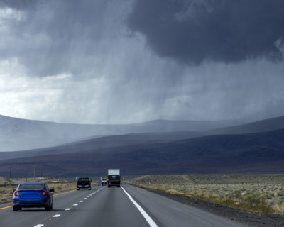 Storm clouds and rain above desert highway