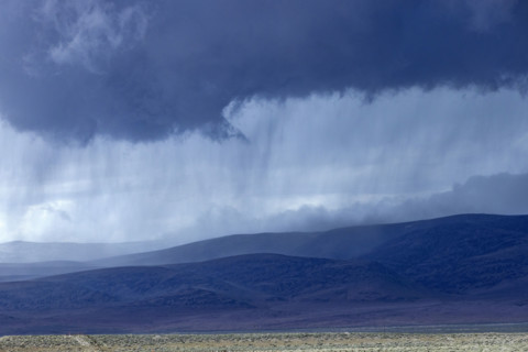 Storm clouds and rain above hills