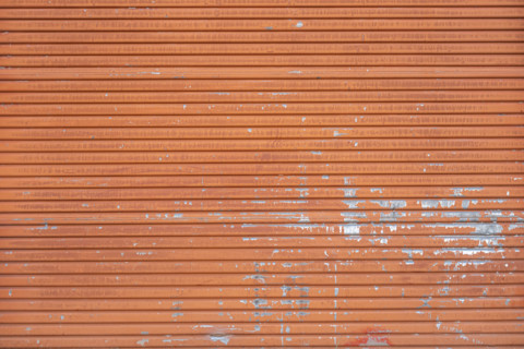 Close-up of old orange metal door