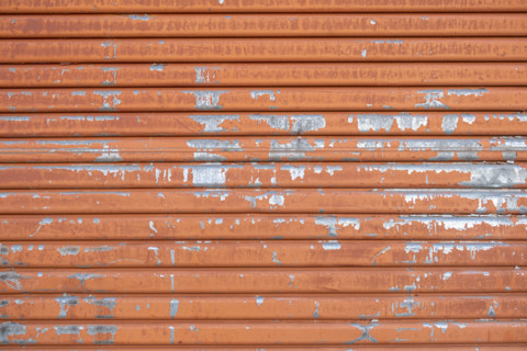 Close-up of old orange metal door