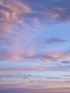 Pale pink clouds against blue sky