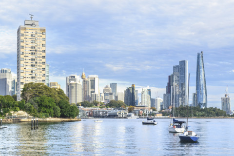 Sailboats anchored in Sydney Harbour, with skyscrapers on background