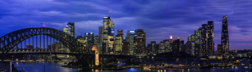 Panoramic view of Sydney CBD and Harbour Bridge illuminated at night