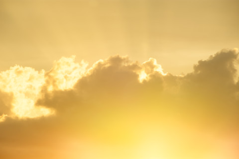 Setting sun shining through gold clouds