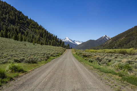 Empty dirt road to distant mountain