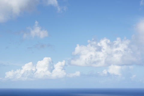 White puffy clouds above calm Caribbean Sea
