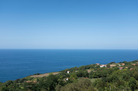 Clear sky over calm sea and green hill. San Sebastian, Gipuzkoa, Spain