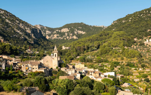 Old town in valley on sunny day. Valldemossa, Mallorca, Spain