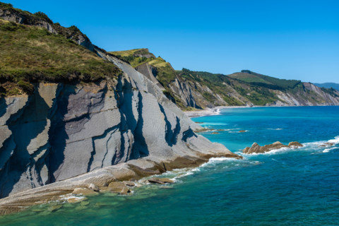 Cliffs and turquoise sea on sunny day. Zumaia, Gipuzkoa, Spain