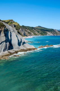 Cliffs and turquoise sea on sunny day. Zumaia, Gipuzkoa, Spain