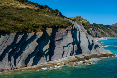 Cliffs and turquoise sea on sunny day. Zumaia, Gipuzkoa, Spain