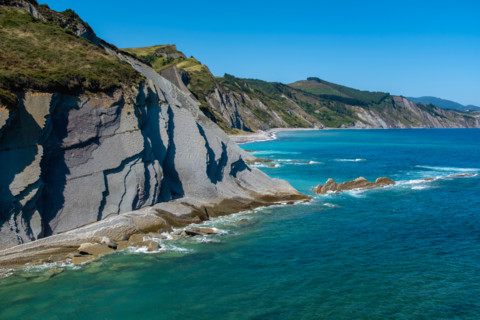 Cliffs and turquoise sea on sunny day. Zumaia, Gipuzkoa, Spain