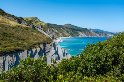 Rocky coast and turquoise sea on sunny day. Zumaia, Gipuzkoa, Spain