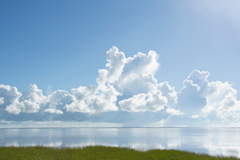 White puffy clouds over calm Saint Joseph Bay. Port St. Joe, Florida, United States