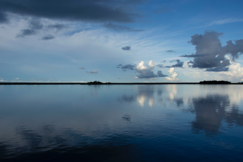 Calm surface of Apalachicola River reflecting evening sky. Apalachicola, Florida, United States