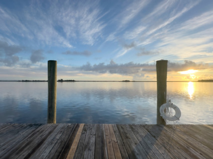 Wooden pier and calm water at sunrise. Apalachicola, Florida, United States