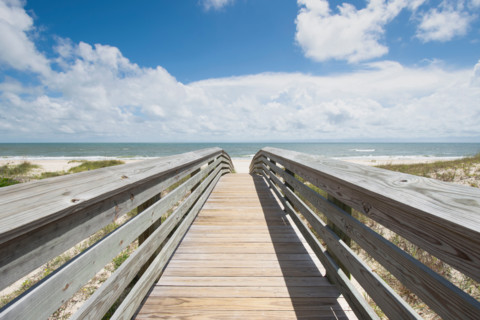 Empty boardwalk leading to beach and calm ocean. St. George Island, Florida, United States
