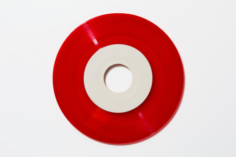 Red vinyl record on white background. New york City, New York State, United States