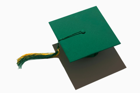Green graduation cap on white background. New york City, New York State, United States