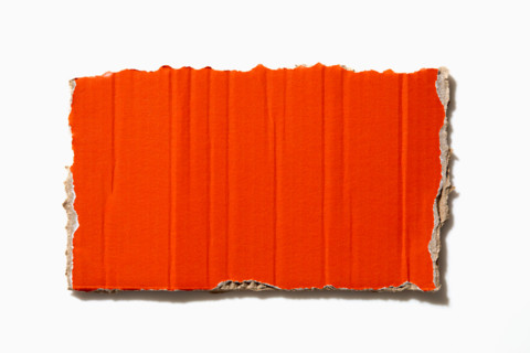 Torn orange paper on white background. New York City, New York State, United States