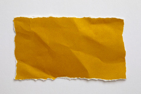 Torn yellow paper on white background. New York City, New York State, United States