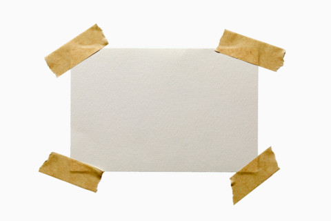 Blank textured paper taped on white background. New York City, New York State, United States