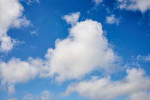Puffy cumulus clouds on blue sky. Kodiak, Alaska, United States