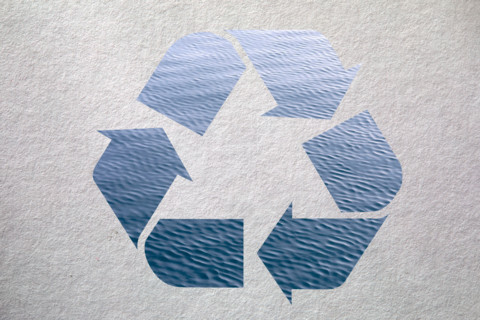 Blue recycling symbol on textured background. New York City, New York State, United States