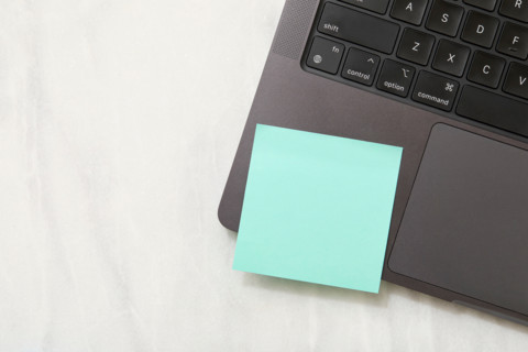 Blank green post it note on laptop. New York City, New York State, United States
