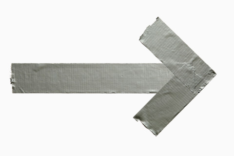 Duct tape in shape of arrow on white background. New York City, New York State, United States
