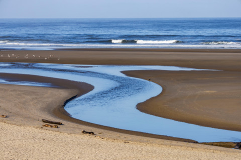 S-shaped Ecola Creek flowing into Pacific Ocean. Cannon Beach, Oregon, United States