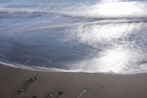 Tide coming in on sandy beach, blurred motion. Gold Beach, Oregon, United States